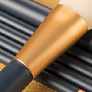 Detail of a durable gold aluminum ferrule on a dark blue makeup brush handle